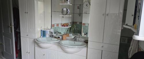 ein Badezimmer mit zwei Waschbecken und einem Spiegel in der Unterkunft maison pour "24H " in Saint-Biez-en-Belin