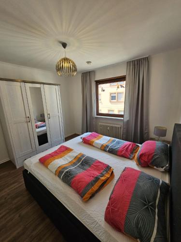a bedroom with two beds with colorful pillows on them at Central-Apartment-Adria in Saarbrücken