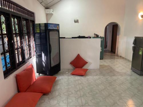 un vestíbulo con sillas rojas y una taquilla en Kuma Surf Camp Hostel, en Weligama