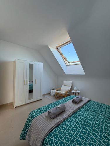 une chambre avec un lit et une lucarne dans l'établissement La Buhardilla, à Moya