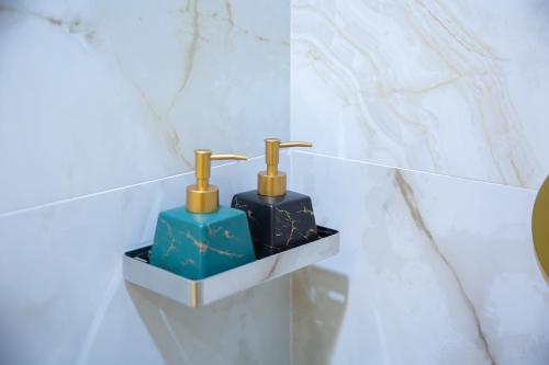 a bathroom with two soap dispensers on a wall at Paradise Found in Dhigurah