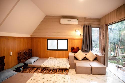 een slaapkamer met een bed, een bank en een raam bij Hill Top Haven Homestay in Phan Thiet