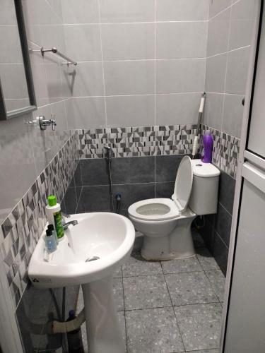 a bathroom with a toilet and a sink at Teratak Nu'aiman With Pool in Bedung
