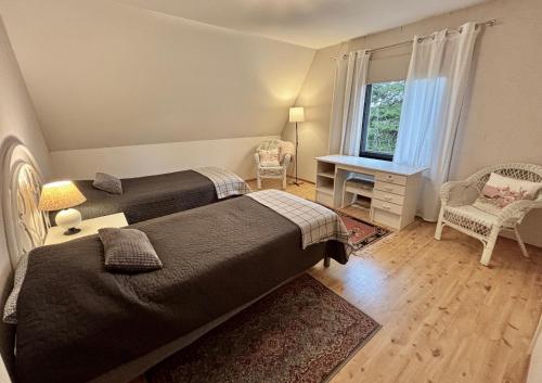 a bedroom with two beds and a window at Villa Nisula - yläkerran asunto in Teuva