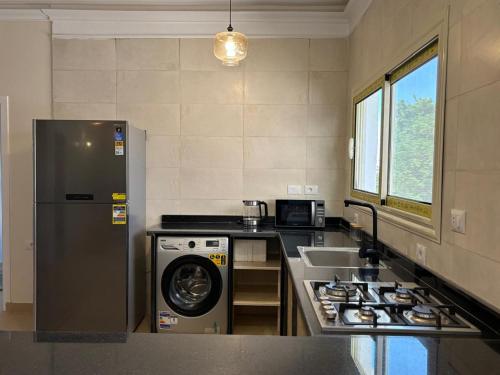 a kitchen with a refrigerator and a washing machine at Golden Sun House II in Abu Simbel