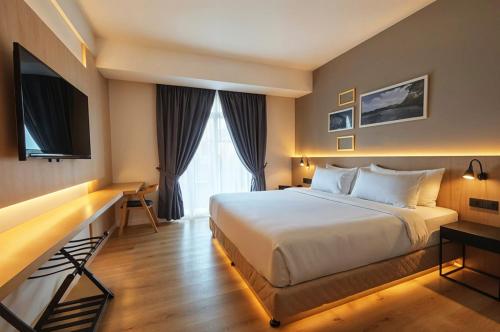 um quarto de hotel com uma cama e uma escrivaninha em Raia Beach Resort Port Dickson em Port Dickson