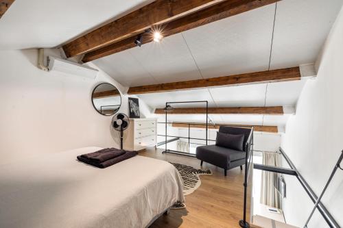 een slaapkamer op zolder met een bed en een stoel bij BnB Purmerland in Purmerend