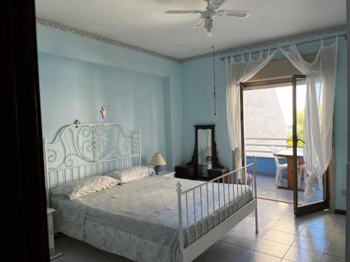 a bedroom with a bed with blue walls and a window at Casa marina in Furci Siculo