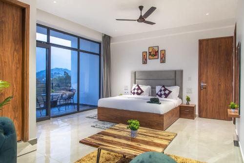 a bedroom with a king sized bed and a balcony at The Pine hill Apartments by Hill crest kasauli in Dharampur