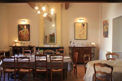 una sala da pranzo con tavoli, sedie e uno specchio di Grande maison Art Nouveau entre mer & garrigue, charme et loisirs au cœur du Sud a Gabian