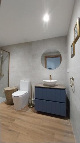 a bathroom with a white toilet and a sink at La Mar de Nueva AT in Nueva de Llanes