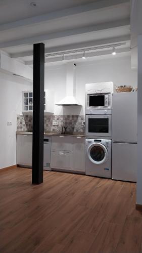 a kitchen with a stove and a washer and dryer at La Mar de Nueva AT in Nueva de Llanes