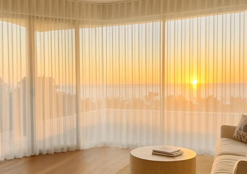 a living room with a couch and a large window at Henley Beachfront Luxury Home With Sauna Just 200m From Henley Square! in Henley Beach