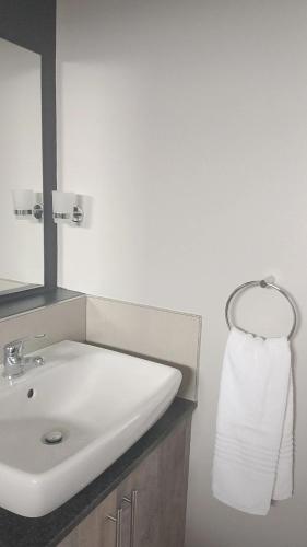 a bathroom with a sink and a mirror and a towel at The Eyrie in Nelspruit