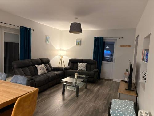 ein Wohnzimmer mit Sofa und Tisch in der Unterkunft Patsys Cottage in Ballyshannon