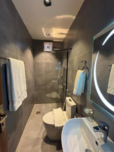 a bathroom with a toilet and a sink at Niyama Hotel in Umm Lajj
