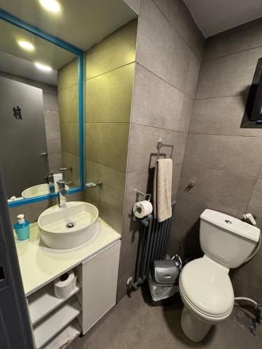 a bathroom with a toilet and a sink and a mirror at The Cozy Inn - Sapphire in Fārayyā