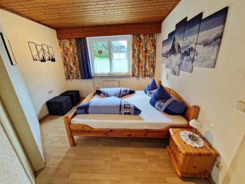 a bedroom with a large bed with blue pillows at Haus Daheim in Sankt Leonhard im Pitztal