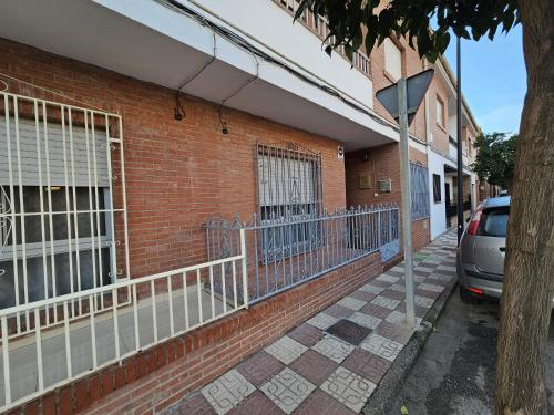 a brick building with a car parked on the street at Casa de Pueblo con Encanto in Valderrubio