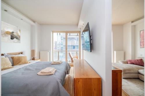biały pokój z łóżkiem i kanapą w obiekcie Studio in central Vilnius w Wilnie