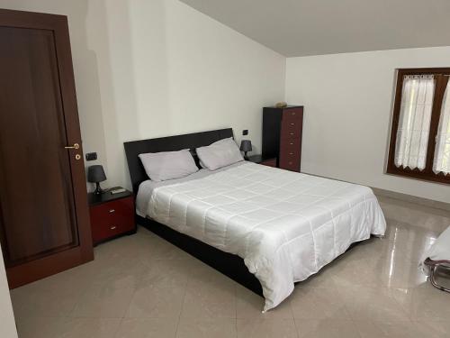 a bedroom with a large bed with a white comforter at Ca’ Vanello in Borgo Tossignano
