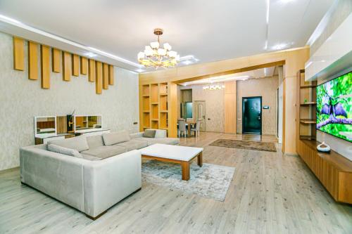 un soggiorno con un divano e una TV di MOXY Home a Baku