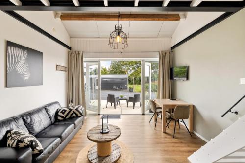 een woonkamer met een bank en een tafel bij BnB Purmerland in Purmerend