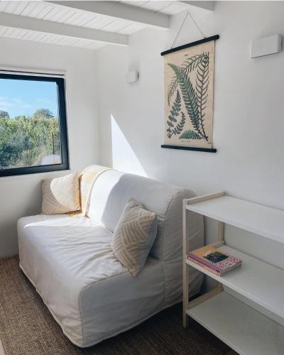 a white couch in a room with a window at Tiny House in Pereiro