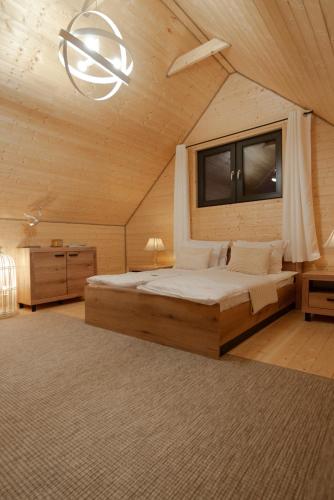 a bedroom with a bed and a window and a chandelier at Żurawia Ostoja Dom z Jacuzzi i Sauną in Tyłowo