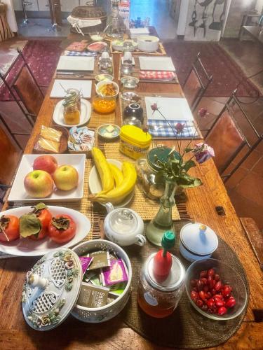 einen Tisch mit Teller mit Lebensmitteln und Obst darauf in der Unterkunft A Casa di Maica in Ferrara