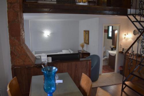 a living room with a table and a bathroom at Muntenia Inn Apartments and Suites in Kalavrita