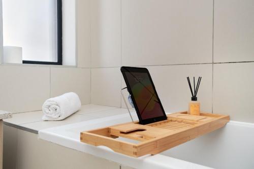 a laptop computer sitting on top of a bathroom counter at The Atrium, Sandton Apartment in Johannesburg