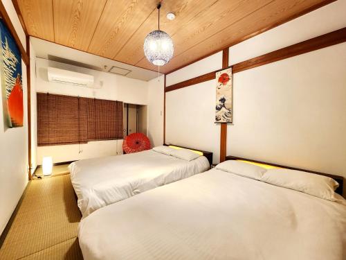 a room with two beds and a window at D,A-House OSAKA in Osaka