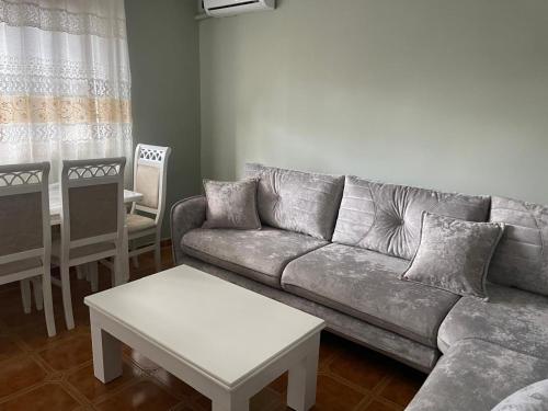 a living room with a couch and a table at Amber Comfort Home in Lushnjë
