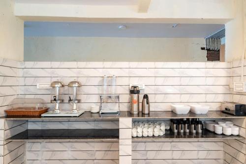 uma cozinha com paredes de azulejos brancos e um balcão em Forest Arch Resort em Mahabaleshwar