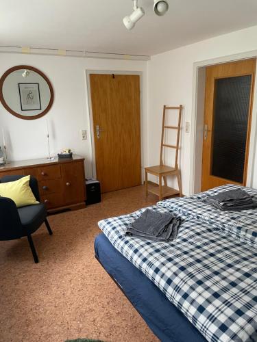 een slaapkamer met een bed, een stoel en een spiegel bij Room!Moor in Schwarzenbach an der Saale