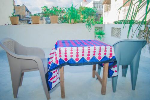 a table with two chairs and a table cloth on it at Amani Guest House Lamu in Lamu