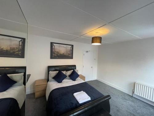 a bedroom with two beds with blue pillows at Livingwell Home in Gravesend