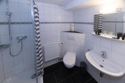 a white bathroom with a toilet and a sink at Goldiger Hirsch B&B mit Gemeinschaftsküche in Immenstadt im Allgäu
