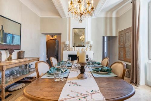 a dining room with a table and chairs and a chandelier at Luxurious Provencal Village House, Walk to Village Pool in Rustrel