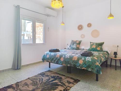 a bedroom with a bed with a floral comforter at Charmante maison familiale 90 m avec patio 8 couchages in Moratalla