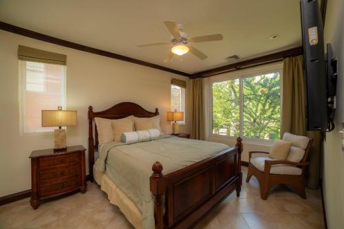 a bedroom with a bed and a fan and a window at AltaVista 2C 3 bdr Ocean View in Los Suenos in Herradura