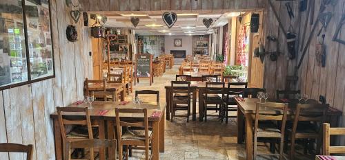 a dining room with wooden tables and chairs at Gite mes pt'tis lits maison chaleureuse 4 chambres in Neufmarché