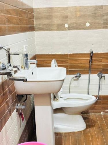 a bathroom with a sink and a toilet at Vaidik Harmony Ayodhya in Ayodhya