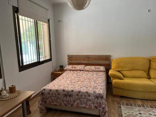 MatolaにあるCa Didiのベッドルーム(ベッド1台、黄色のソファ付)