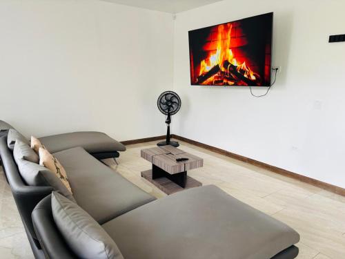 a living room with a couch and a fire on the wall at Casa en Puyo Amazonía "Villa Coral" in Puyo