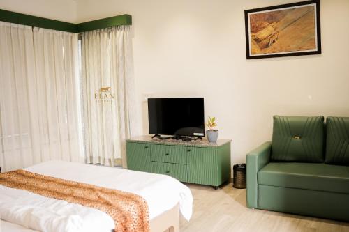 een slaapkamer met een bed, een tv en een stoel bij Elan Luxuria Jawai in Bijāpur