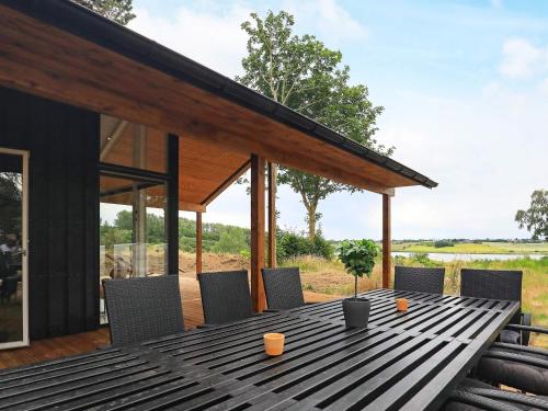 - une table en bois avec des chaises sur la terrasse dans l'établissement 12 person holiday home in Millinge, à Millinge