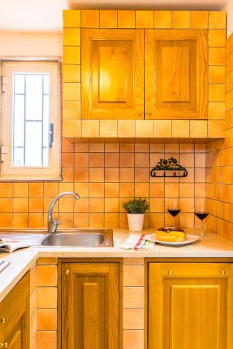 a kitchen with wooden cabinets and a sink and a plate of food at Tenuta Nunziata - food, event, biofarm in Torre Annunziata