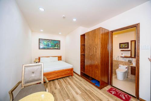 a small bedroom with a bed and a toilet at Hotel Anh Đức 2 in Ga Phú Văn